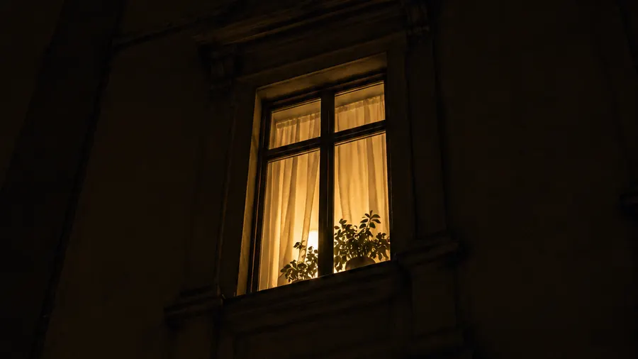 Una finestra illuminata di notte sulla facciata di un palazzo